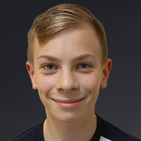 Porträt von Valentin Krüger mit kurzem, blondem Haar und freundlichem Lächeln vor dunklem Hintergrund.